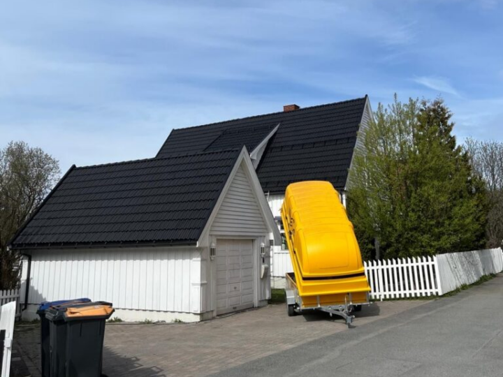 Tak av rødbrun teglstein med synlig vekst av mose og lav langs valm- og gradrenner.