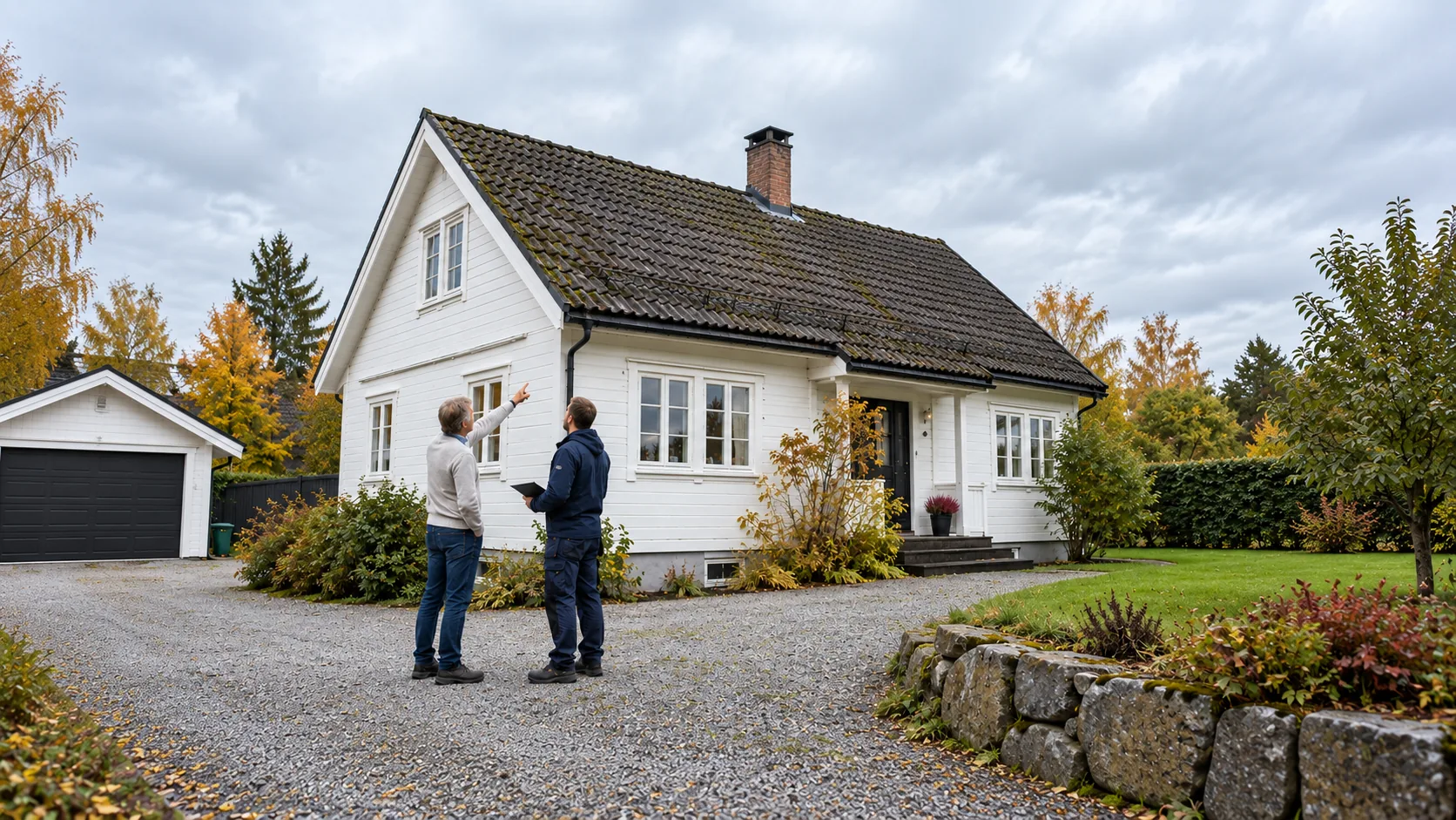 Rådgiver og huseier ser på taket til et hvitt bolighus med takstein